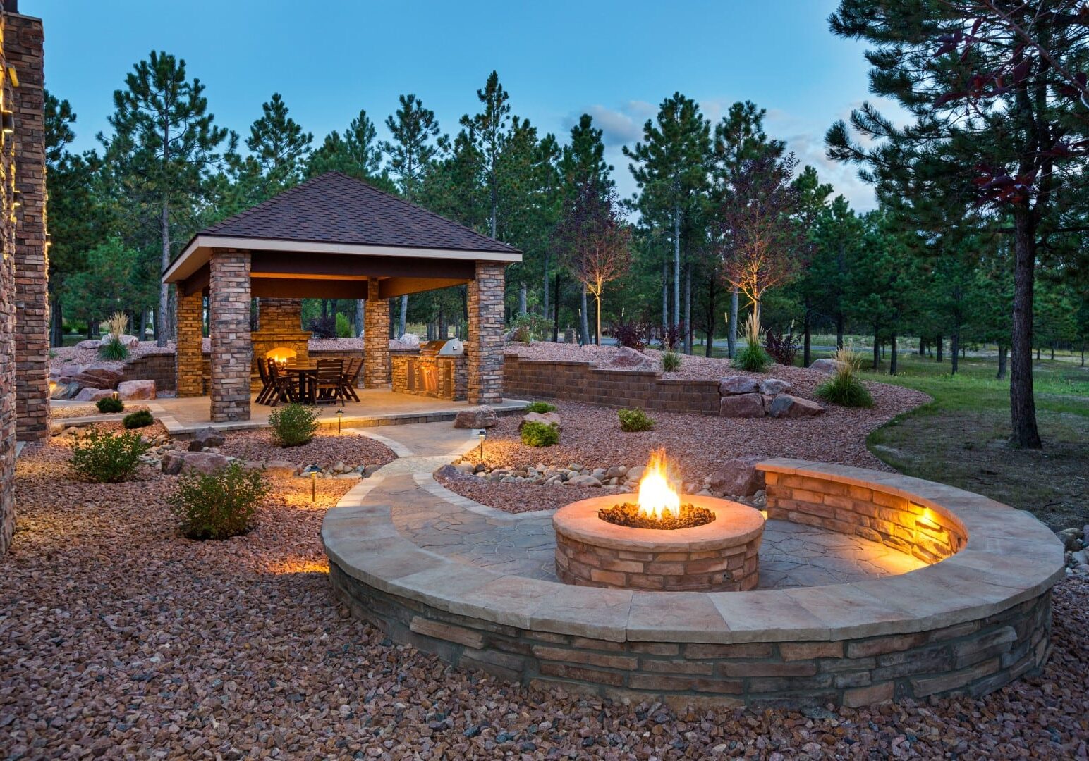 Cozy outdoor fire pit with gazebo and seating.